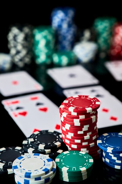 Casino chips playing cards and dices on dark reflective background