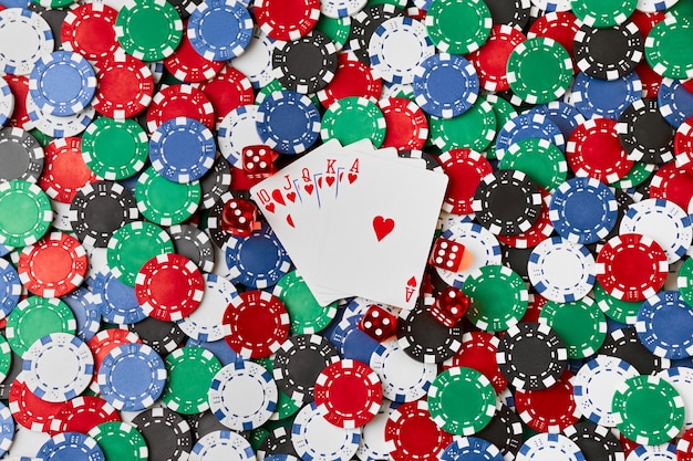 Фишки казино, игральные карты и кости на столе из зеленой ткани