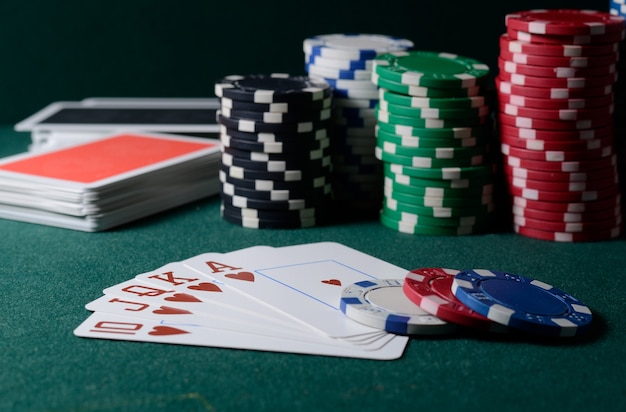 Casino chips and royal flush cards combination on the green table. Poker game theme