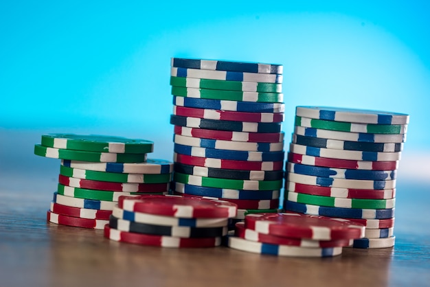 Photo casino chips on wooden table with blue background