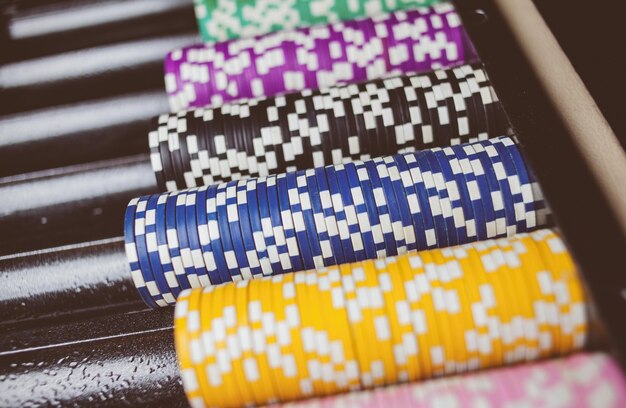 カジノのカラフルなポーカーチップは、スタックのビンテージ写真処理のゲームテーブルにあります