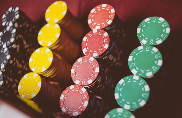 Красочные покерные фишки казино лежат на игровом столе в стопке обработки винтажных фотографий