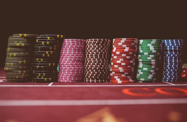 Красочные покерные фишки казино лежат на игровом столе в стопке обработки винтажных фотографий