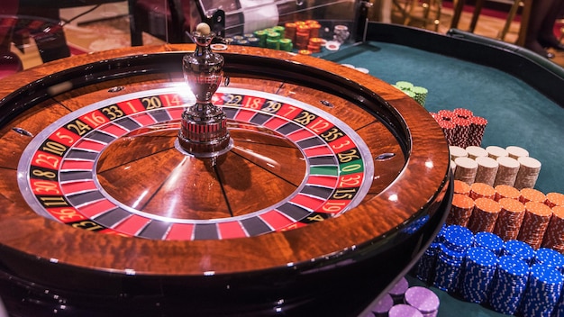 Casino gokken en entertainment concept roulettetafel en stapel pokerfiches