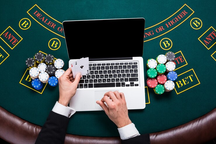 Casino, online gambling, technology and people concept - close up of poker player with playing cards