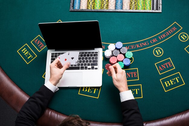 Casino, online gokken, technologie en mensenconcept - close-up van pokerspeler met speelkaarten