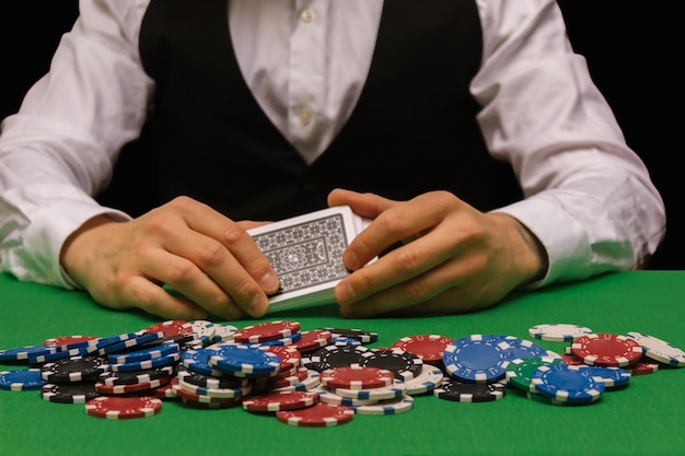 Casino worker, dealing from the deck of cards to play poker\
with a lot of chips dealer, bet, fortune, luck