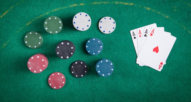 Casinofiches en kaarten op groene tafel.