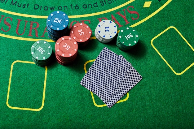 Casinofiches en kaartspel liggend op groene casinotafel, pokerspelconcept, bovenaanzicht.