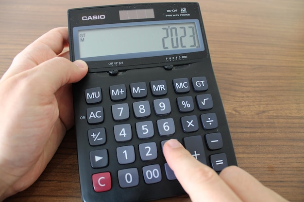 A casio calculator is being used by a person.