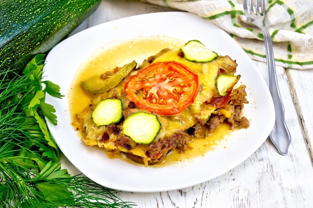 Casserole from minced meat and zucchini in plate on table