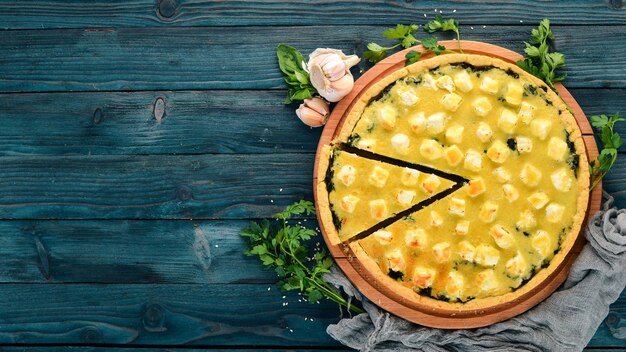 Casserole of spinach and cheese On a wooden background Top view Copy space