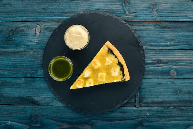 Casserole of spinach and cheese On a wooden background Top view Copy space