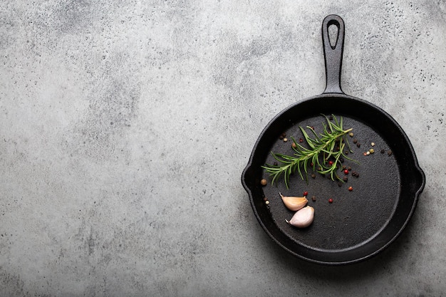 Cast iron frying pan with rosemary garlic pepper oil copy space