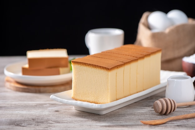 Castella kasutera Heerlijk Japans gesneden biscuitvoedsel op witte plaat over rustieke houten lijst sluit omhoog gezond het eten ontwerp van de exemplaarruimte