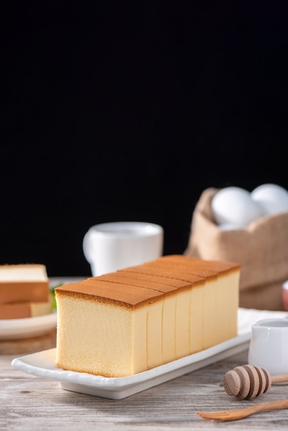 Castella kasutera Heerlijk Japans gesneden biscuitvoedsel op witte plaat over rustieke houten lijst sluit omhoog gezond het eten ontwerp van de exemplaarruimte