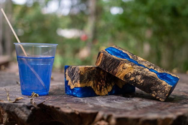 Casting blue epoxy resin burl wood cube on old table