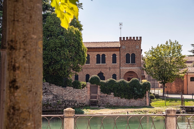 イタリアのトレヴィーゾ市の城は、周囲の木々によってフィルタリングされています