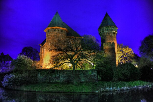 Photo a castle with a tree in front of it that is lit up