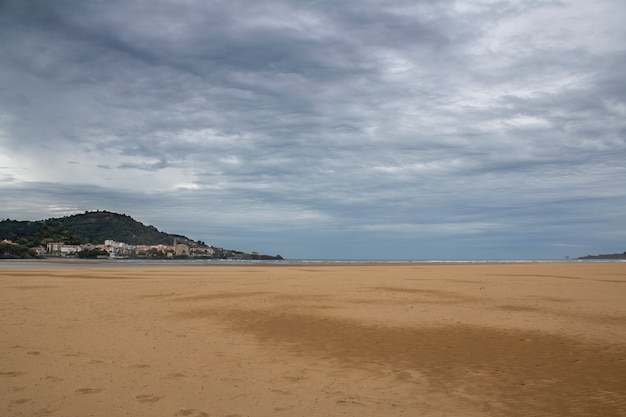 Castro Urdiales beach in a day with grey clouds.