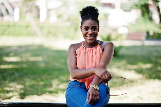 Ragazza afroamericana casuale con la camminata colorata dei sacchetti della spesa all'aperto. acquisto alla moda della donna di colore.