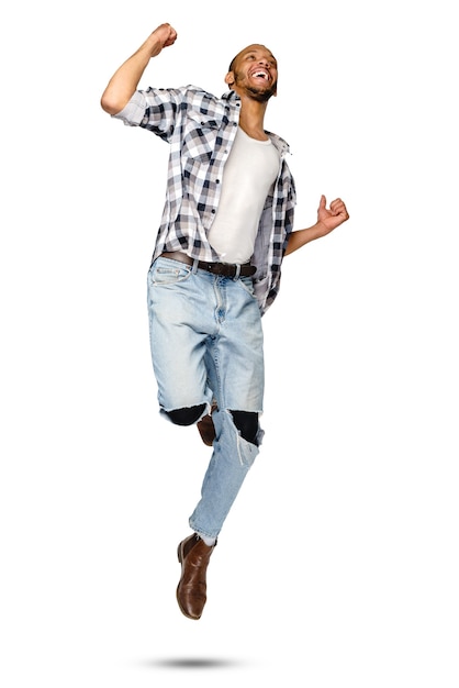 Casual african-american man jumping in studio over white background