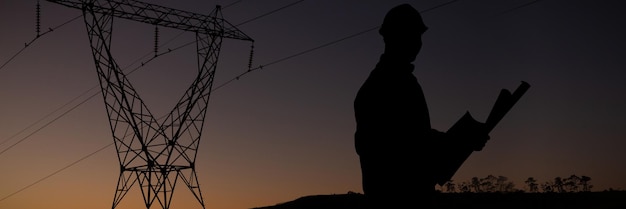 Casual architect against the evening electricity pylon silhouette