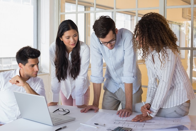 Casual architecture team working together at desk