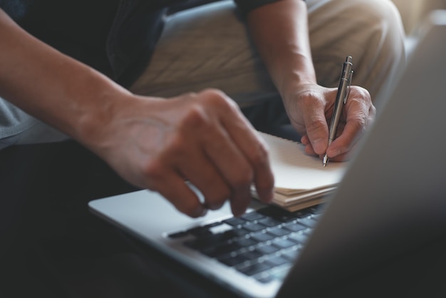 Photo casual business man planning on project planner notepad surfing the internet on office table