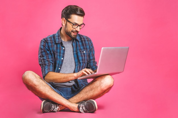 カジュアルなビジネスの男性は、仕事やラップトップコンピューターでインターネットの閲覧をリラックスしました。フリーランスの座っているとホームオフィスでラップトップのキーボードで入力