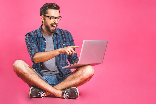 Casual business man relaxed working and browsing internet on laptop computer. Freelance sitting and typing on laptop keyboard at home office