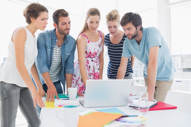 Casual business people using laptop together