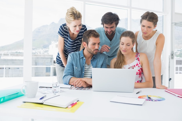 Casual business people using laptop together