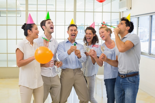 Foto squadra casual business festeggia con champagne e petardi