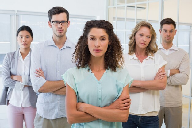 Casual business team frowning at camera with arms crossed