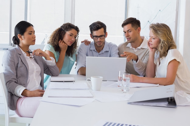 Casual business team having a meeting using laptop