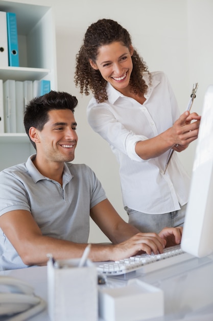 Casual business team looking at computer together at desk