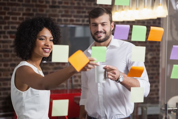 Casual business team looking at sticky notes