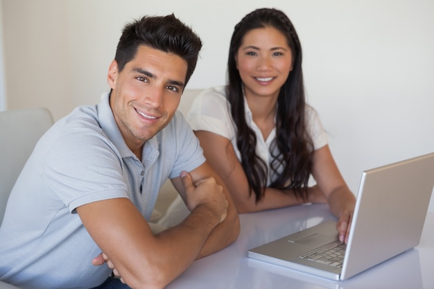 Casual business team using laptop together at desk