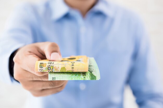 Casual businessman giving money, South Korean WON banknotes