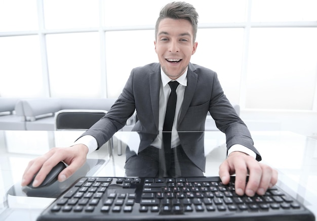 Casual businessman looks at the camerakeyboard