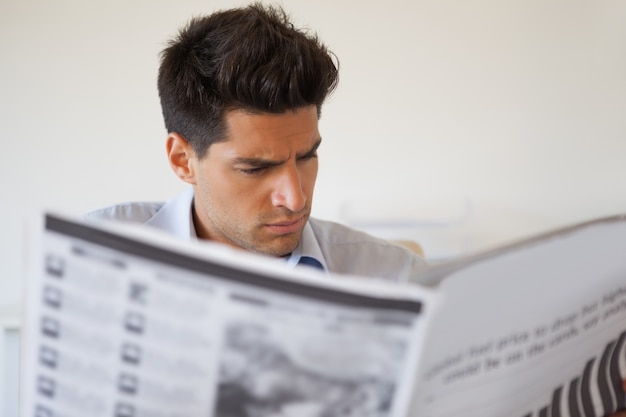 新聞を読んでいるカジュアルなビジネスマン