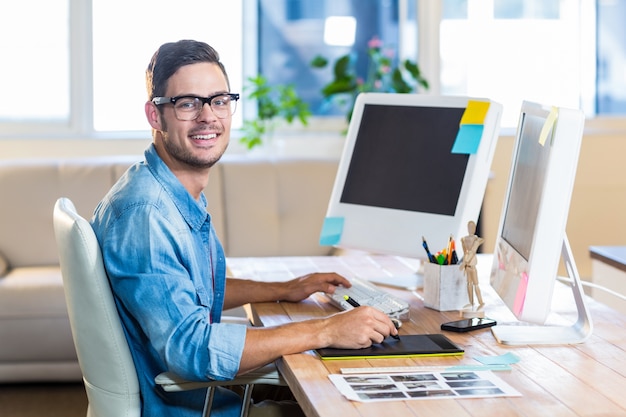 Casual businessman using digitizer at his desk