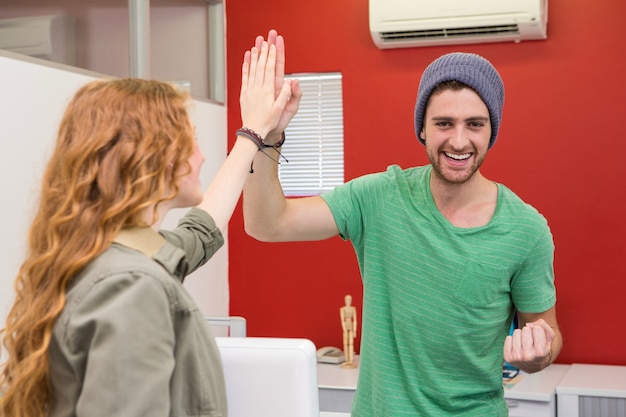 Casual businessman and woman high fiving