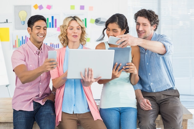 Casual businesspeople using digital tablet with colleagues behind in office