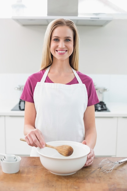 Casual cheerful blonde holding wooden spoon