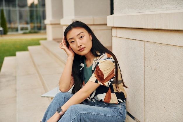 In casual clothes Young asian woman is outdoors at daytime