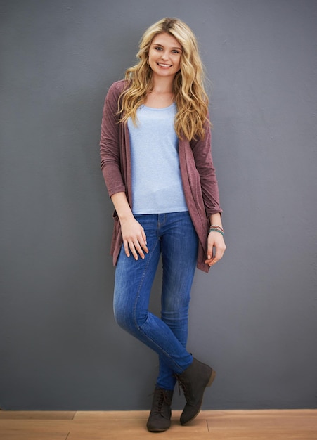 Casual and content Portrait of a young woman standing against a gray background