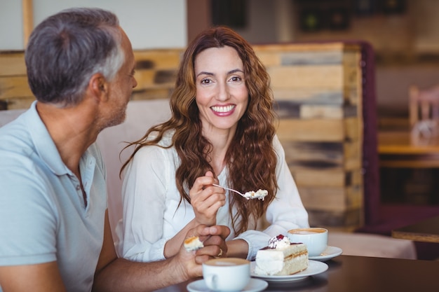 Casual couple having coffee and cake together