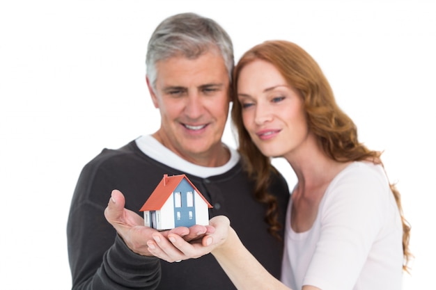 Casual couple holding small house